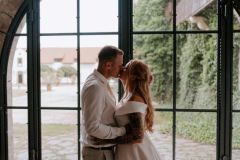 Svatební fotografie u renesančních oken zámku Libouchec, spojení historie a romantiky.