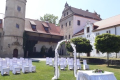 Detail svatebního oblouku s výzdobou na míru na pozadí renesanční architektury zámku Libouchec.