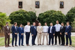 Záběr na svatební hosty v exteriérech zámku Libouchec po venkovním obřadu. 