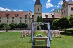 Slavobrána na nádvoří zámku Libouchec s výhledem na historické křídlo.