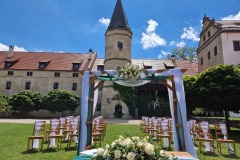 Slavobrána na nádvoří zámku Libouchec s výhledem na historické křídlo.